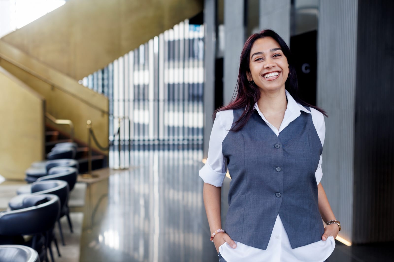 A TFE Hotels team member smiling in a hotel lobby